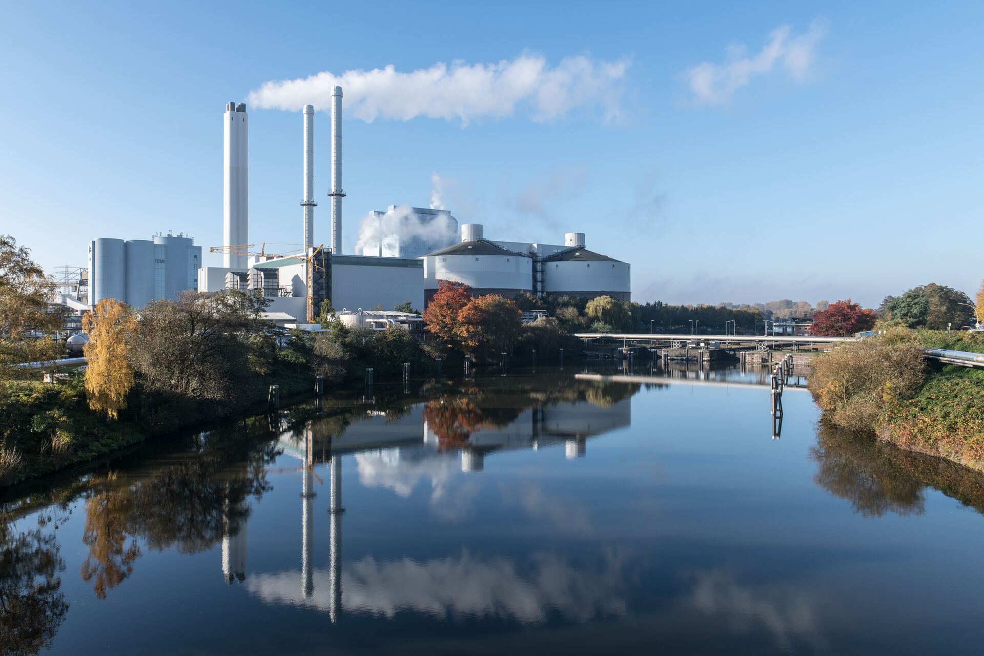 Heizkraftwerk mit Dampfwolken an einem Fluss